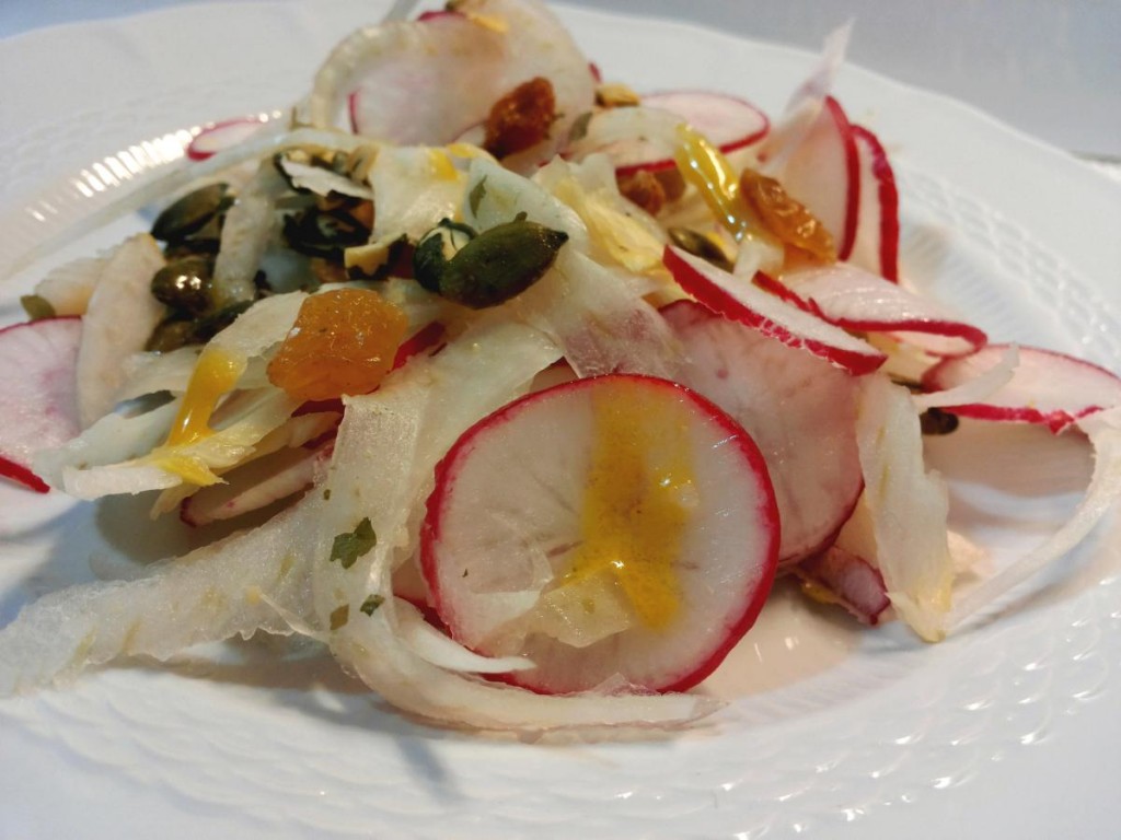 Insalata con finocchi, ravanelli, uva sultanina e semi di zucca condita con vinagrette di senape