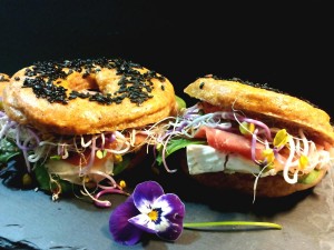 Bagels integrali con semi di sesamo neri farciti con prosciutto crudo camembert spinacino e germogli di ravanello