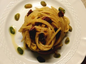 Spaghetti con pesto di pistacchi,a corza di limone e pomodori secchi