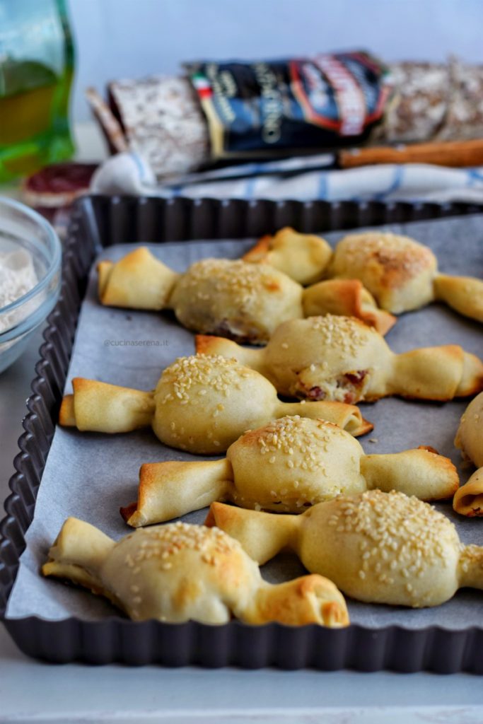 Antipasto a base di pasta matta ripiena si ricotta e salame a forma di caramella con decorazione di semi di sesamo sulla superficie