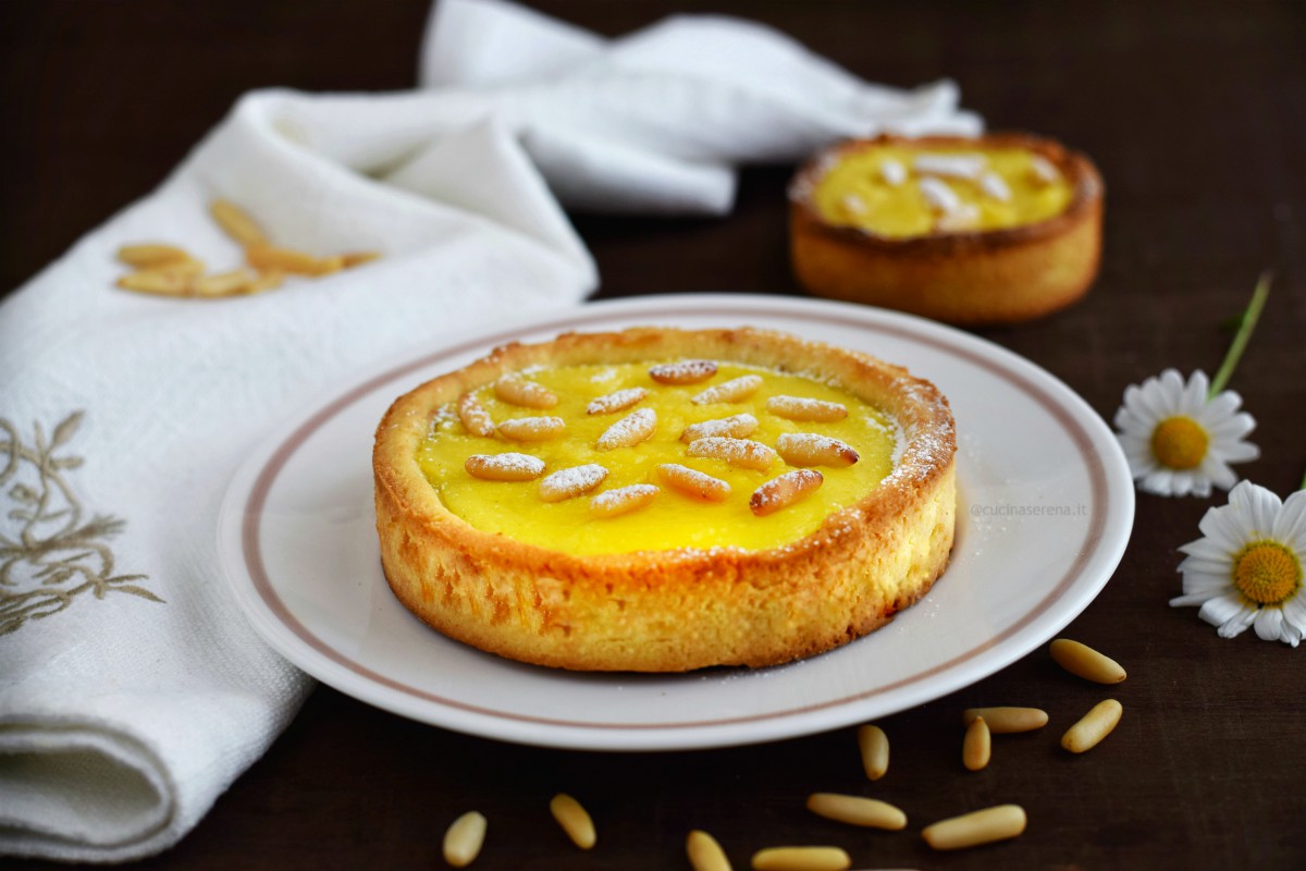 Torta della nonna golosa con uno strato di crema di nocciole sotto quello di crema e pinoli. 