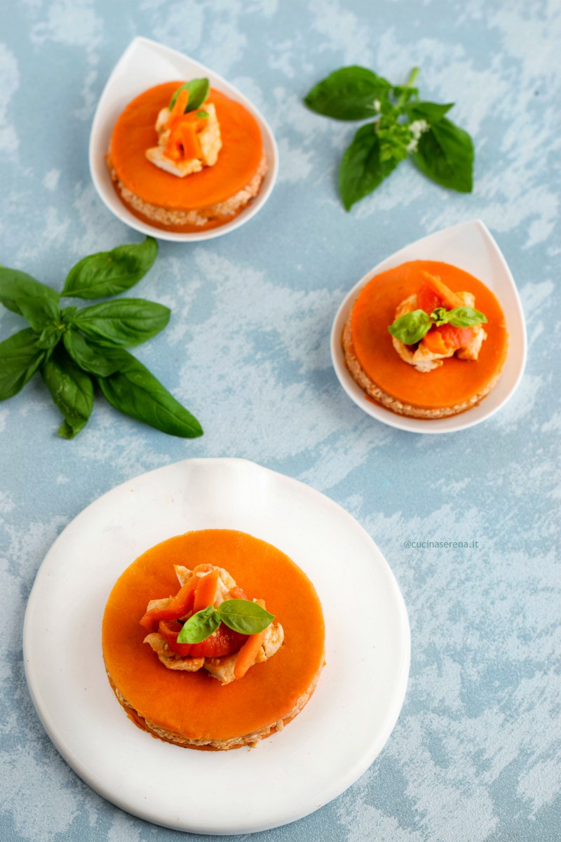 Pollo in gelatina di peperoni di Carmagnola, due dischi di gelee di pomodoro rosso con in mezzo pollo ai peperoni.