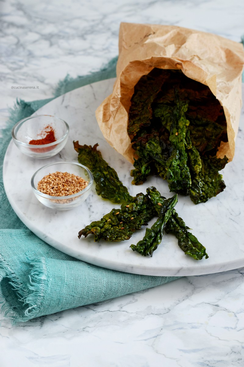 Chips di cavolo nero - kale chips al forno servite come snack in un sacchetto di carta alimentare come fossero patatine - 