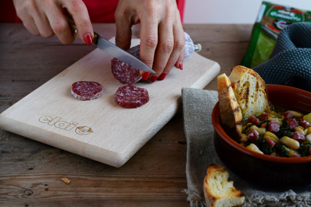 immagine della mani mentre affettano salame golosetto Clai (cacciatorino) da mettere nella ribollita