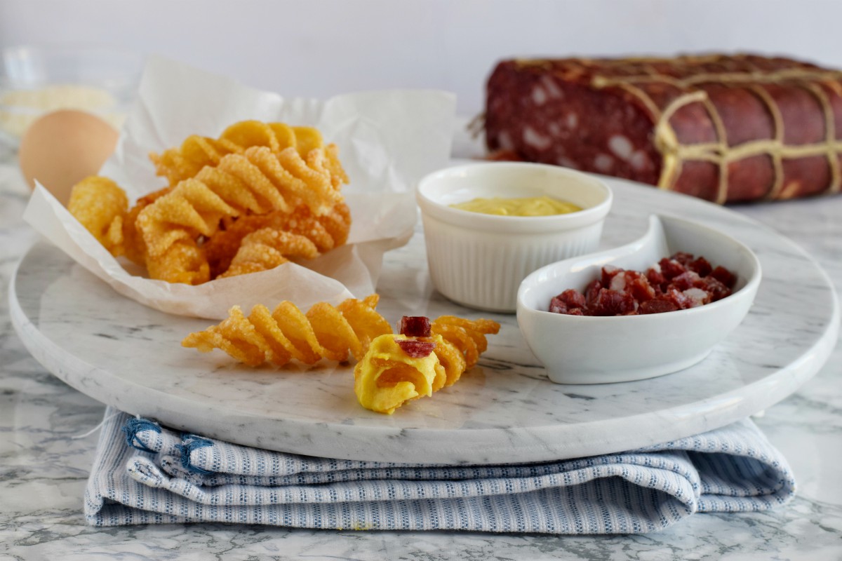 Carbonara gourmet fatta con pasta soffiata fritta, crema di formaggio e uova servita come antipasto