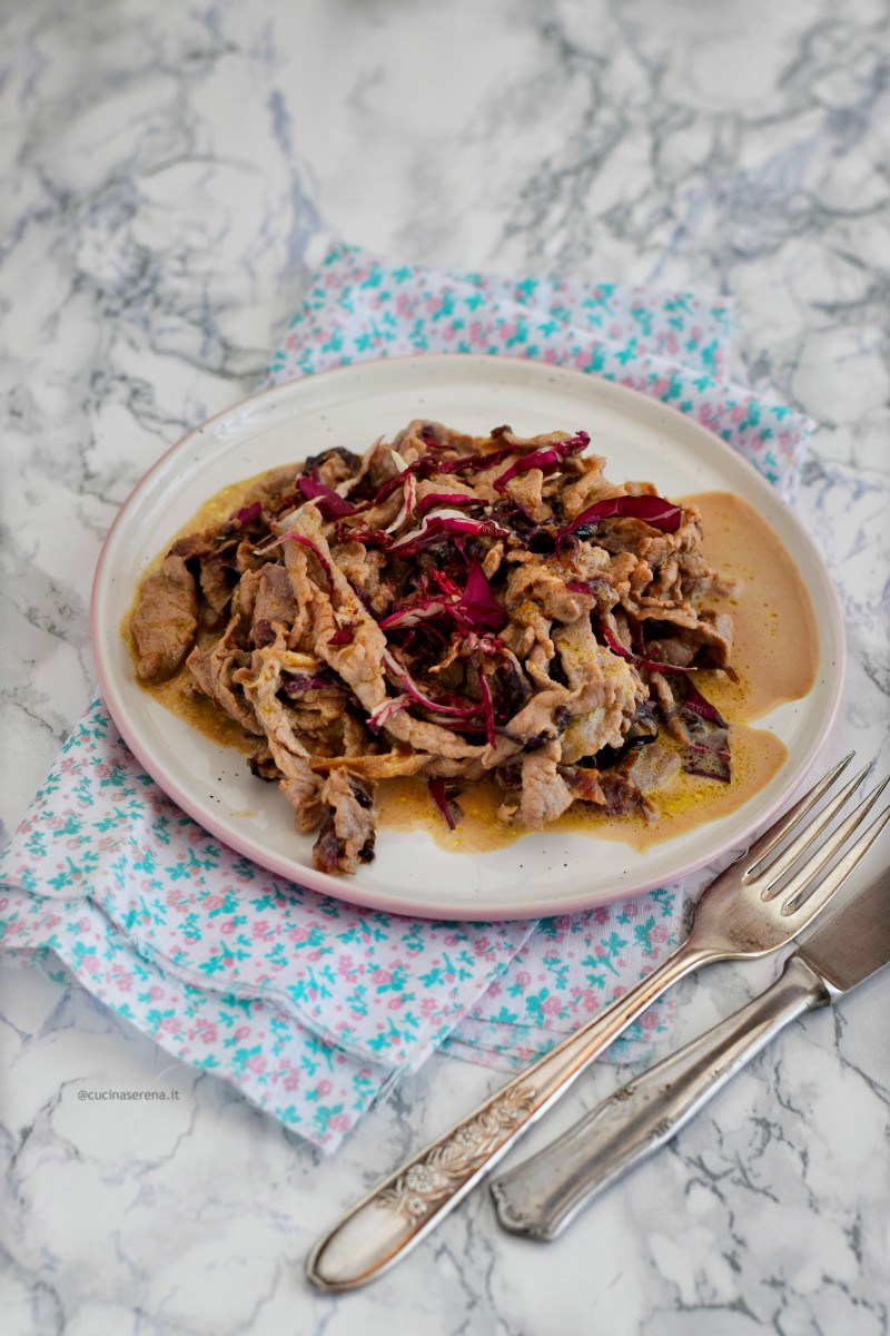 Straccetti di carne radicchio e gorgonzola nella foto serviti in un piatto con il loro sughetto cremoso.