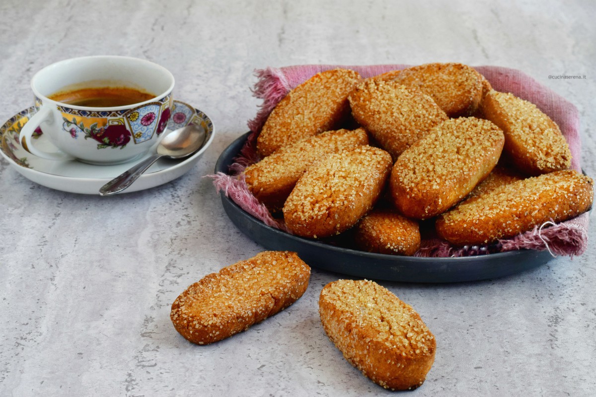 Biscotti light senza burro nè uova, nella foto presentati in una teglia tonda con un tovagliolo di lino accanto una tazzina con un caffè