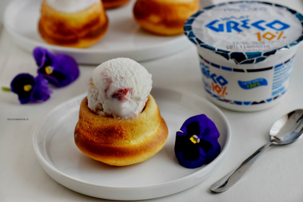 Cupcakes allo yogurt greco farcite con frozen yogurt greco nella foto servite in un pisttino con un cucchiaino e decorazioni di fiori violette