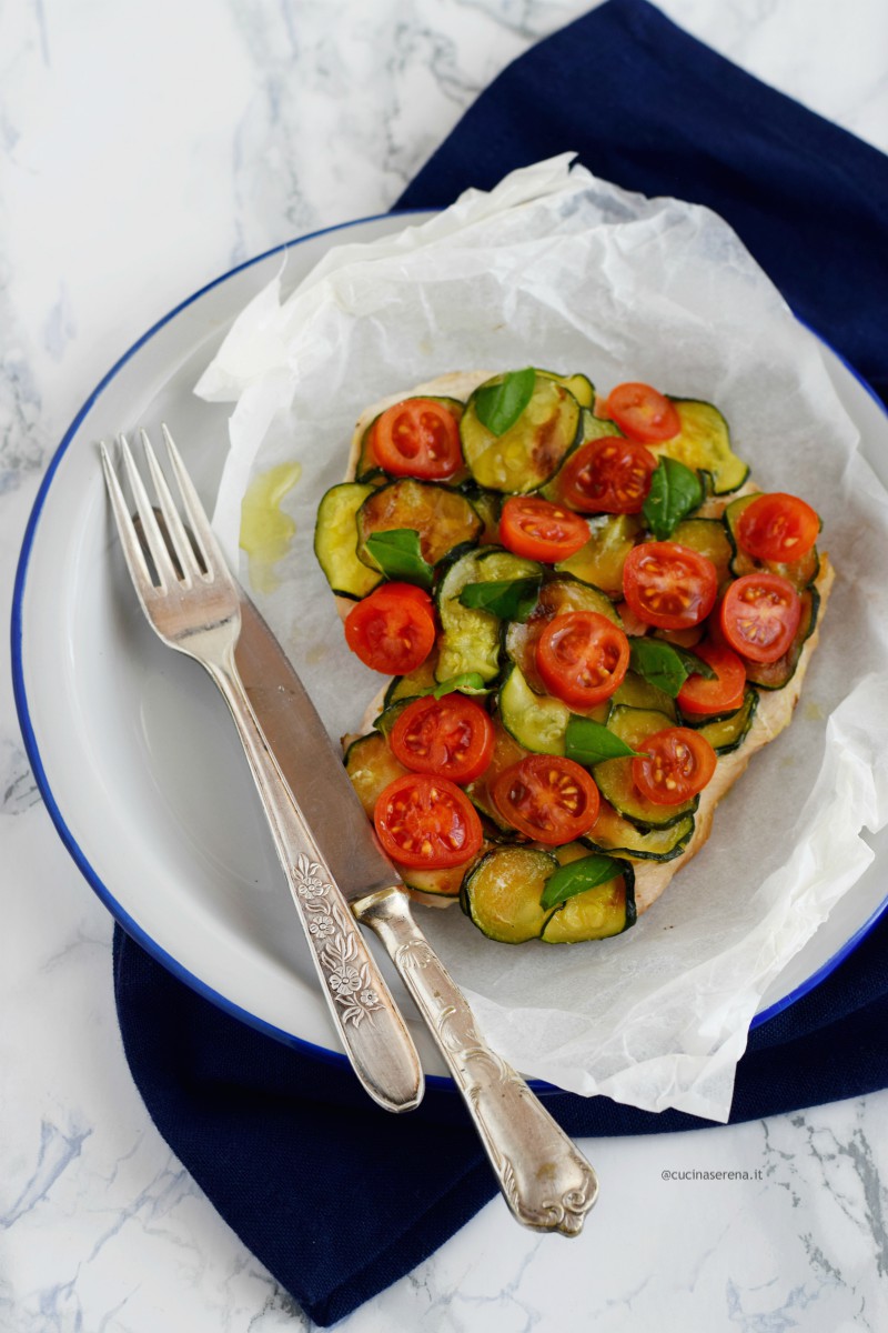 Petto di tacchino al cartoccio in padella con zucchine e pomodorini - ricetta light nella foto servito ne piatto con tutto il suo cartoccio