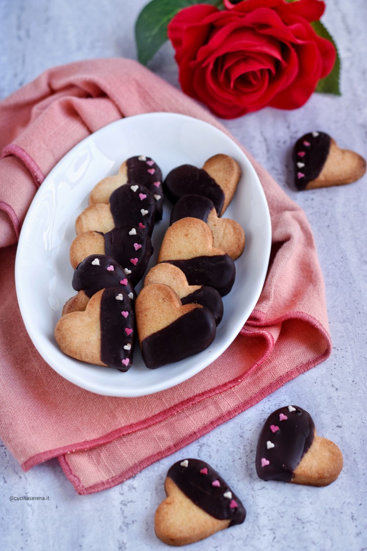 Biscotti di frolla a cuore ricoperti di cioccolato con zuccherini a forma di cuore