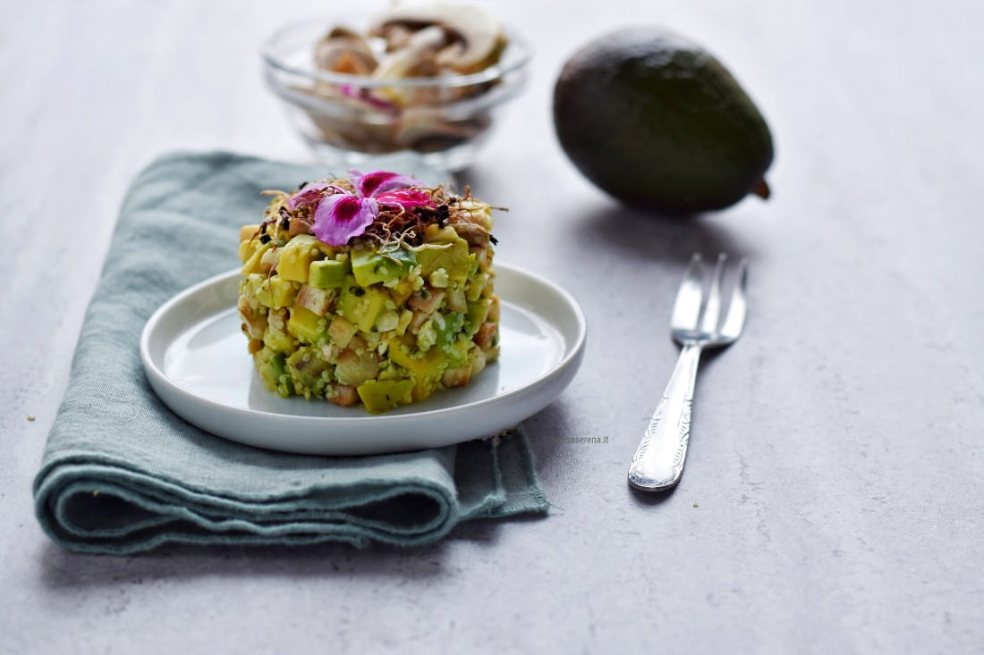 Tartare di avocado, funghi champignon, anacardi e semi di canapa decorata con germogli e fiori eduli